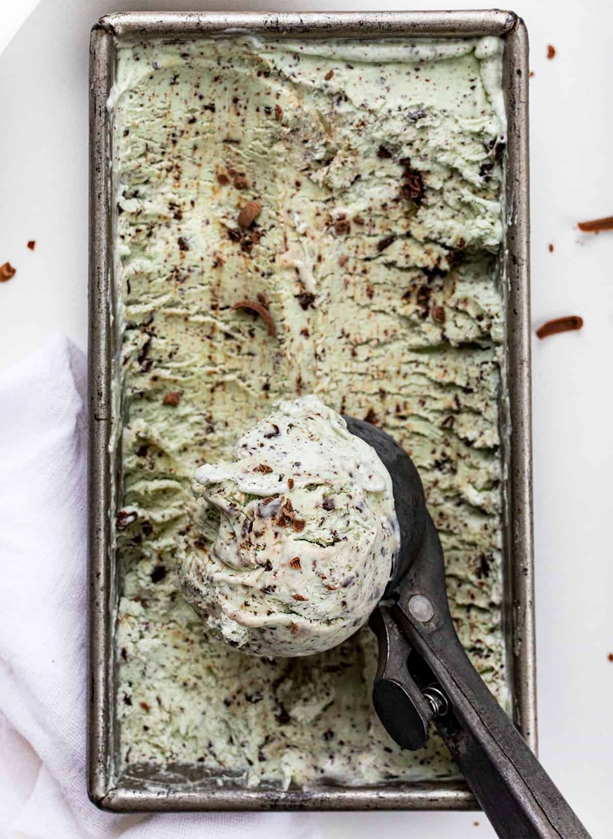 Overhead of a pan of No-Churn Mint Chocolate Chip Ice Cream with a Scoop Filled with Ice Cream