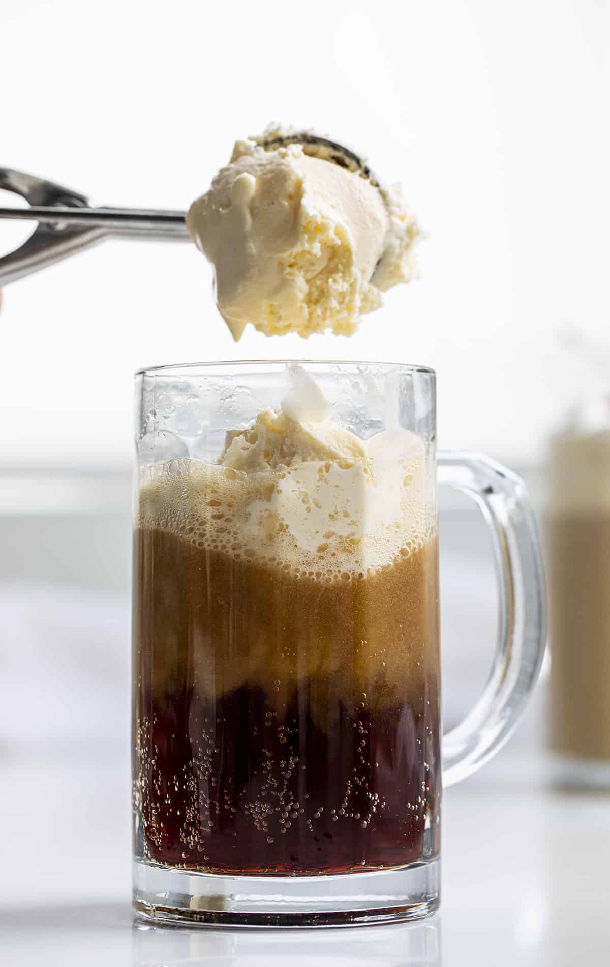 Adding Ice Cream to a Mug To Make a Root Beer Float.