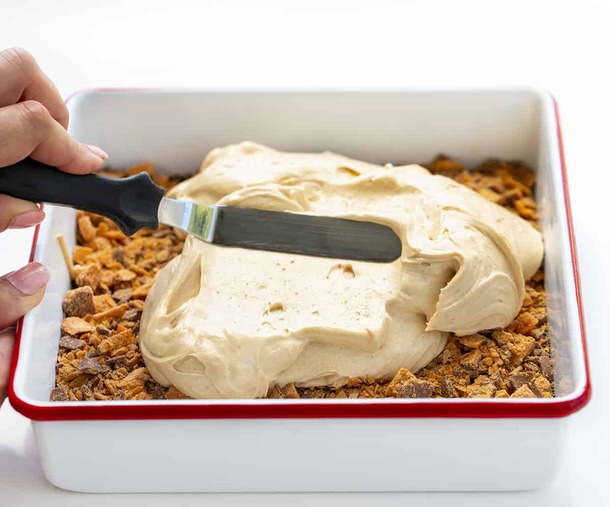 Smoothing out a Layer of Pudding on Butterfinger Lush Dessert. Dessert, No Bake Dessert, Butterfinger Desserts, Layered Desserts, Lush, Lush Desserts, dessert recipes, i am baker, iambaker