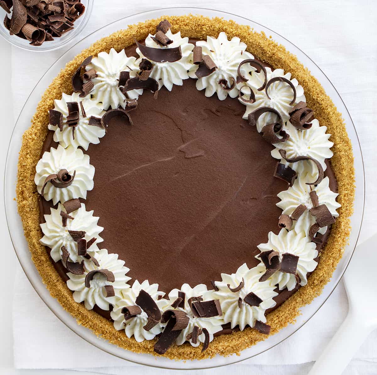 Overhead of a Chocolate Icebox Pie with Whipped Cream and Chocolate Curls. Dessert, Pie, No Bake Pie, Chocolate Desserts, no Bake Chocolate Desserts, Summer Dessert, Dark Chocolate Dessert, What to Serve to Company for Dessert, recipes, chocolate, chocolate curls, Whipped Cream, i am baker, iambaker.