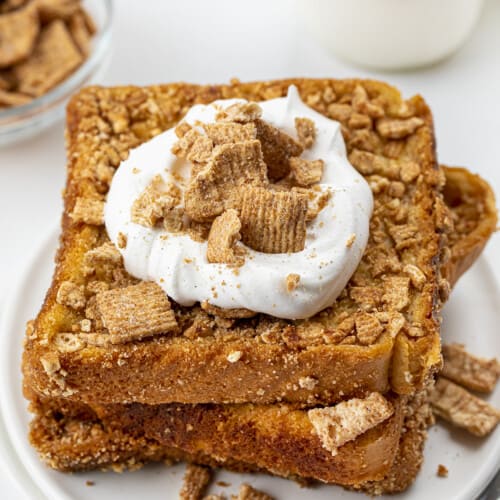 Stack of Cinnamon Toast French Toast Breakfast with Whipped Cream and Cereal on Top