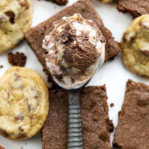 Scoop of Cookie Dough Brownie Ice Cream on Top of Brownies and Cookie Dough.