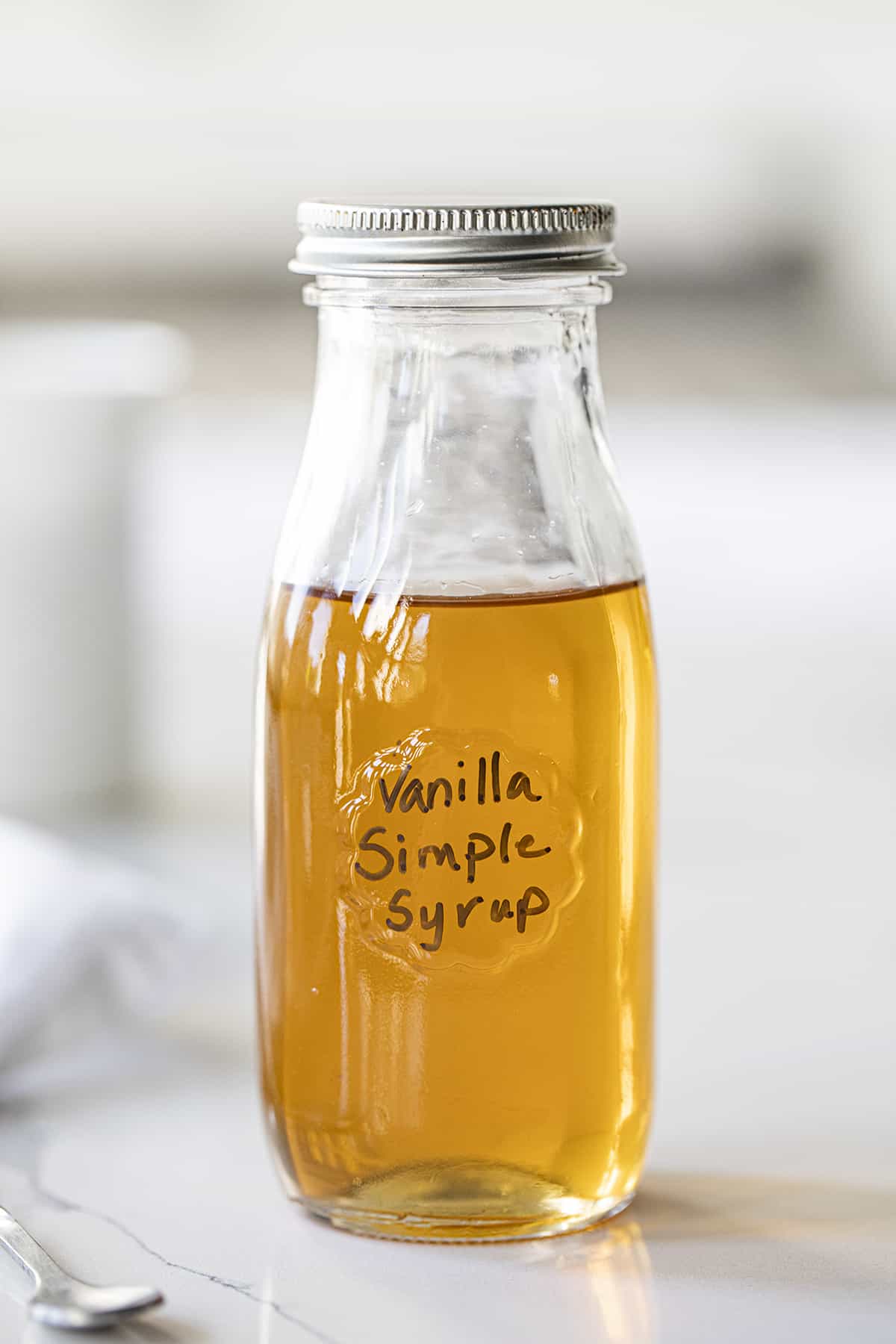 Bottle of Vanilla Simple Syrup on Counter. Simple Syrup, How to Make Simple Syrup, Vanilla Simple Syrup, How to Use Simple Syrup, Cocktail Syrup, drinks, beverages, recipes, iambaker, i am baker.
