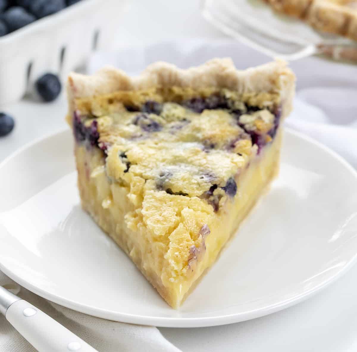 Slice of Blueberry Buttermilk Pie on a White Plate. Dessert, Baking, Pie, Pie Crust, Best Pie Crust, Buttermilk Pie, Blueberry Pie, Christmas Dessert, Summer Dessert, Old Fashioned Dessert, i am baker, iambaker