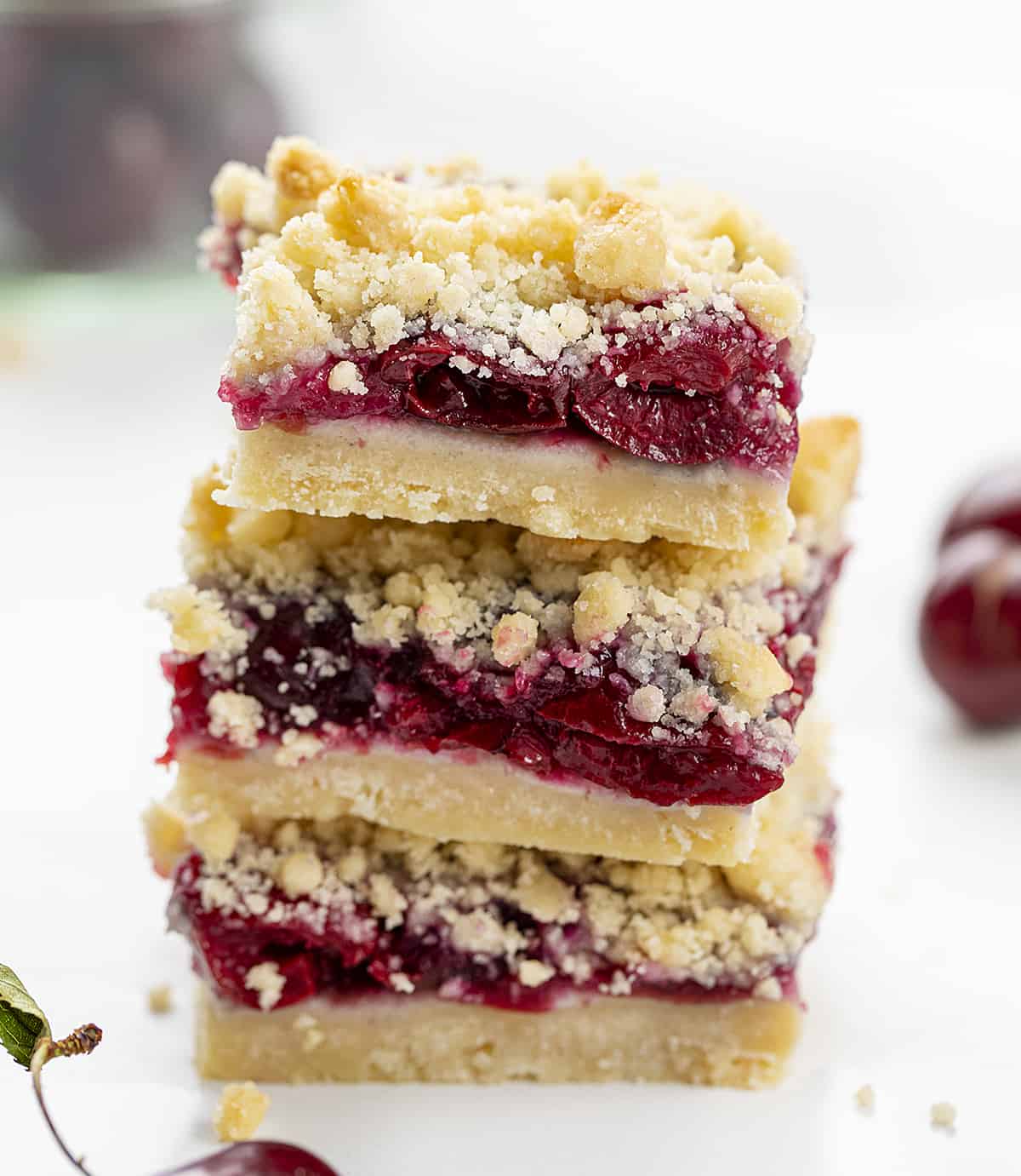 Stack of Cherry Pie Bars with Real Cherries Around. Dessert, Baking, Bars, Cherry Bars, Cherry Pie Bars, Homemade Cherry Pie Filling, Easy Bars, Real Cherry Desserts, Summer Baking, Winter Baking, Christmas Recipes, i am baker, iambaker.