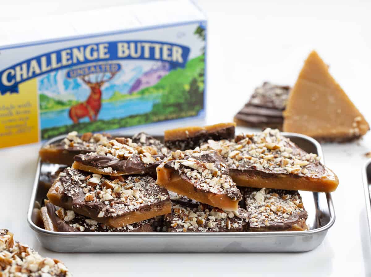 Tray of English Toffee Broken into Pieces and a Box of Challenge Butter Behind it.