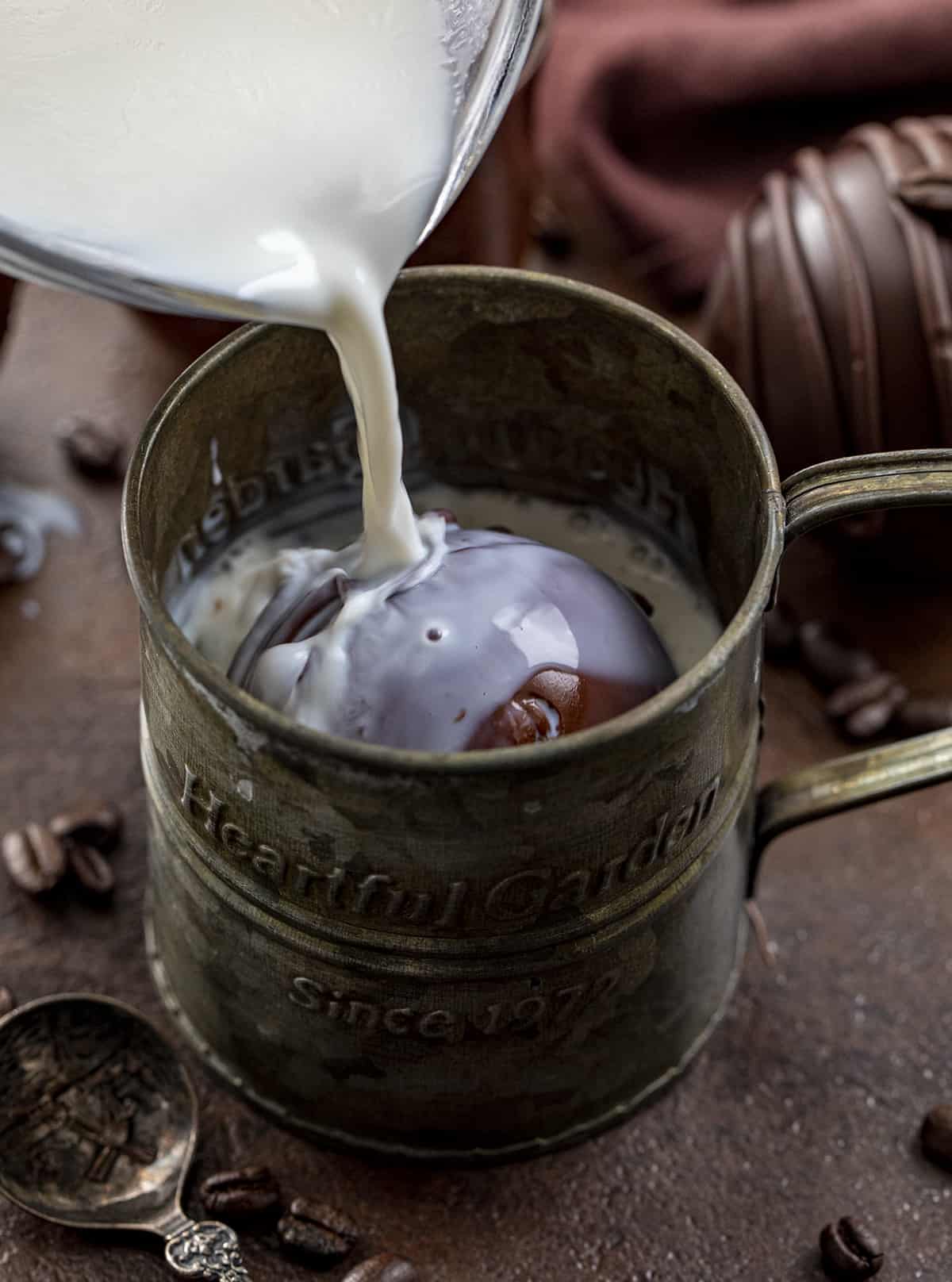 Pouring Hot Milk over a Mocha Coffee Bomb. Hot Cocoa Bombs, Hot Chocolate Bombs, How to Make Hot Chocolate Bombs, Best Chocolate Bomb Flavors, Costco Chocolate Bombs, Hot Chocolate Bombs AllRecipes, How to Store Chocolate Bombs, Hot to Store Hot Cocoa Bombs, How to Store Mocha Coffee Bombs, i am baker, iambaker