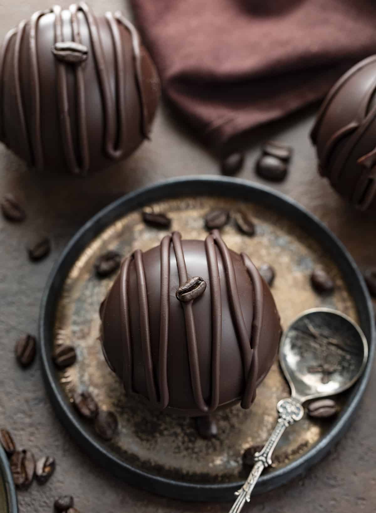 Chocolate Mocha Coffee Bomb on a Plate with Spoon. Hot Cocoa Bombs, Hot Chocolate Bombs, How to Make Hot Chocolate Bombs, Best Chocolate Bomb Flavors, Costco Chocolate Bombs, Hot Chocolate Bombs AllRecipes, How to Store Chocolate Bombs, Hot to Store Hot Cocoa Bombs, How to Store Mocha Coffee Bombs, i am baker, iambaker