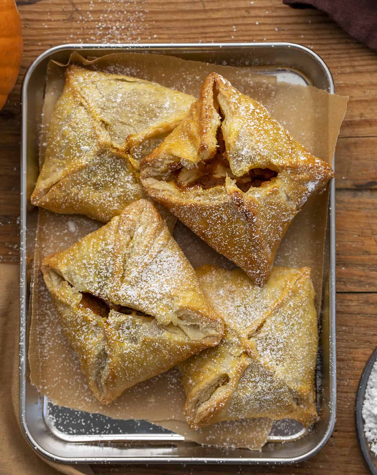 Pumpkin Cream Cheese Danish in a Tray Dusted with Confectioners Sugar. Breakfast, Snack, Pumpkin Danish, Puff Pastry, Pumpkin Puff Pastry, Pumpkin Cream Cheese Puff Pastry, Breakfast Danish, Dessert, Baking, Holiday Recipes, Thanksgiving Breakfast, Christmas Breakfast, i am baker, iambaker