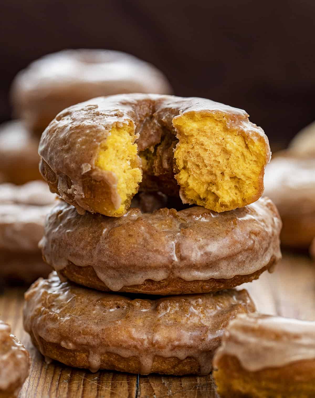 Stack of Glazed Pumpkin Donuts with Top Donut Halved and Showing Texture inside. Breakfast, Donuts, Donut Recipes, Pumpkin Donut Recipes, How to Fry Donuts, Pumpkin Donuts in the Air Fryer, How to Bake Donuts, Baked Pumpkin Donuts, Brunch Ideas, Fall Baking, Best Pumpkin Donuts, i am baker, iambaker