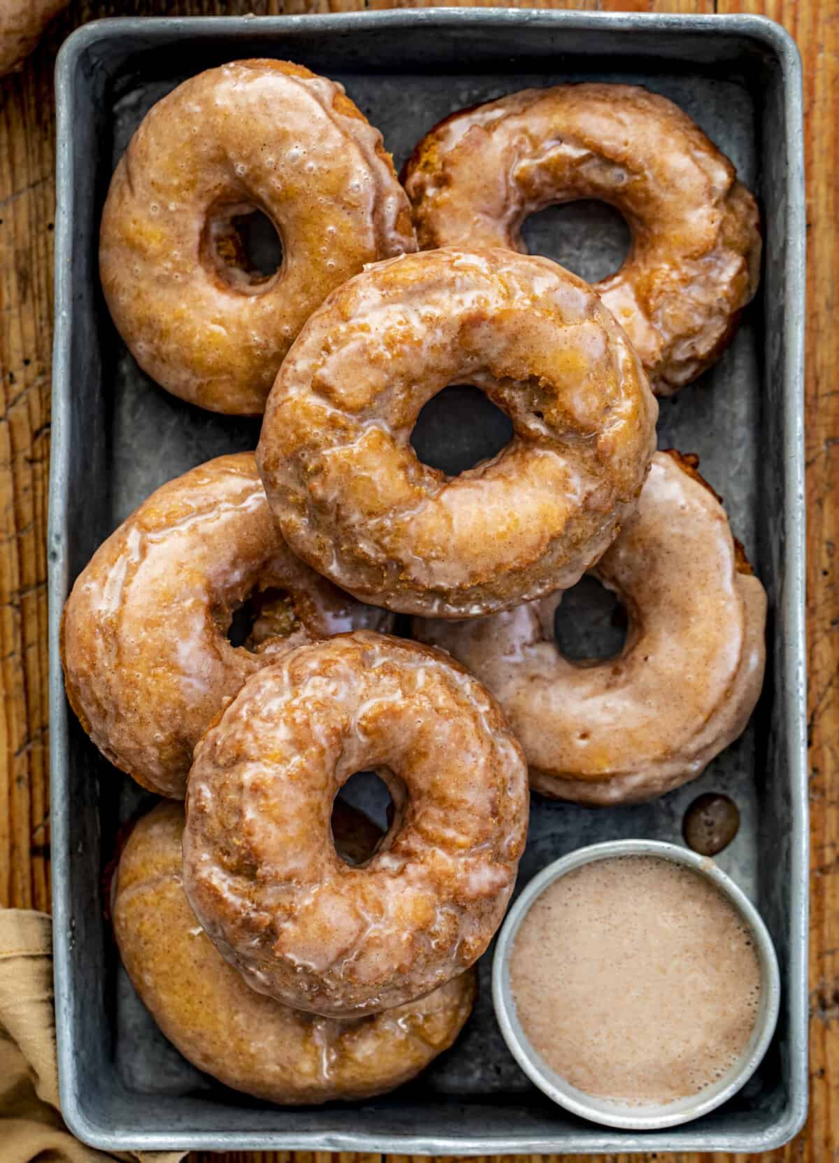 Overhead of a Pan of Glazed Pumpkin Donuts. Breakfast, Donuts, Donut Recipes, Pumpkin Donut Recipes, How to Fry Donuts, Pumpkin Donuts in the Air Fryer, How to Bake Donuts, Baked Pumpkin Donuts, Brunch Ideas, Fall Baking, Best Pumpkin Donuts, i am baker, iambaker