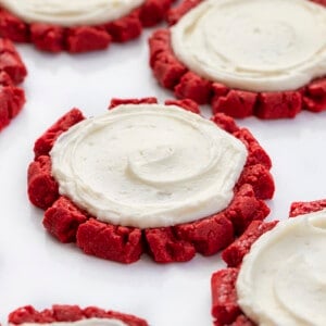 Red Velvet Cookies with Swirled Cream Cheese Frosting on a White Surface. Dessert, Cookies, Baking, Christmas Cookies, Holiday Baking, Cookie Exchange, Red Velvet Recipes, Red Velvet Cookies, Cream Cheese Frosting, Frosted Sugar Cookies, i am baker, iambaker