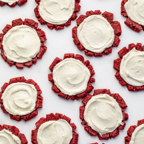 Red Velvet Cookies with Cream Cheese Frosting on a White Surface from Overhead. Dessert, Cookies, Baking, Christmas Cookies, Holiday Baking, Cookie Exchange, Red Velvet Recipes, Red Velvet Cookies, Cream Cheese Frosting, Frosted Sugar Cookies, i am baker, iambaker