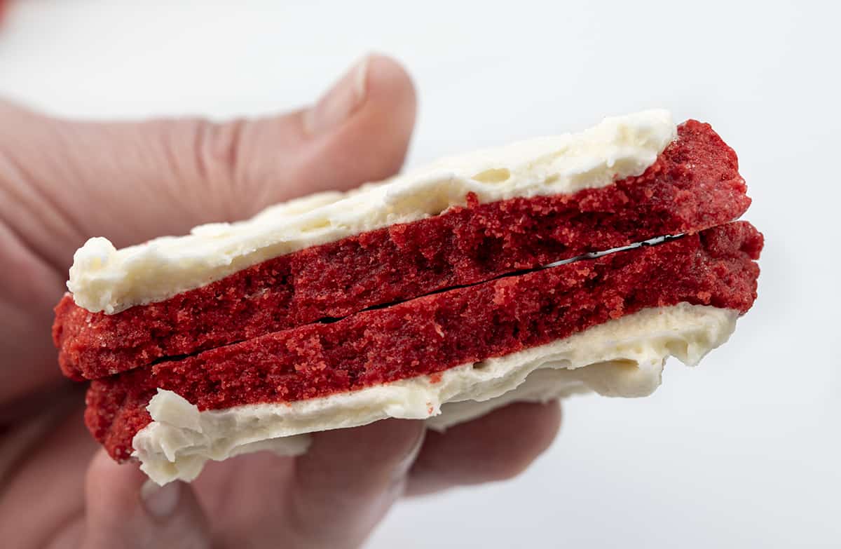 Hand Holding a Broken in Half Red Velvet Cream Cheese Cookie Showing the Soft Inside Texture. Dessert, Cookies, Baking, Christmas Cookies, Holiday Baking, Cookie Exchange, Red Velvet Recipes, Red Velvet Cookies, Cream Cheese Frosting, Frosted Sugar Cookies, i am baker, iambaker