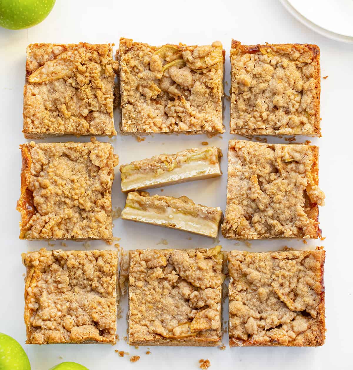 Apple Shortbread Bars on a Counter Cut Into Pieces with the Center Piece Cut Smaller and Flipped on Its Side to Show Bar Layers. 
