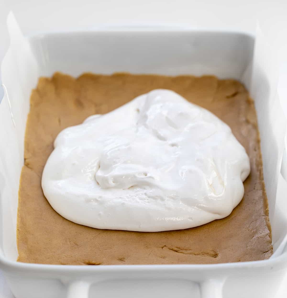 Adding Marshmallow Fluff to Raw Peanut Butter Cookie Batter in a Pan.