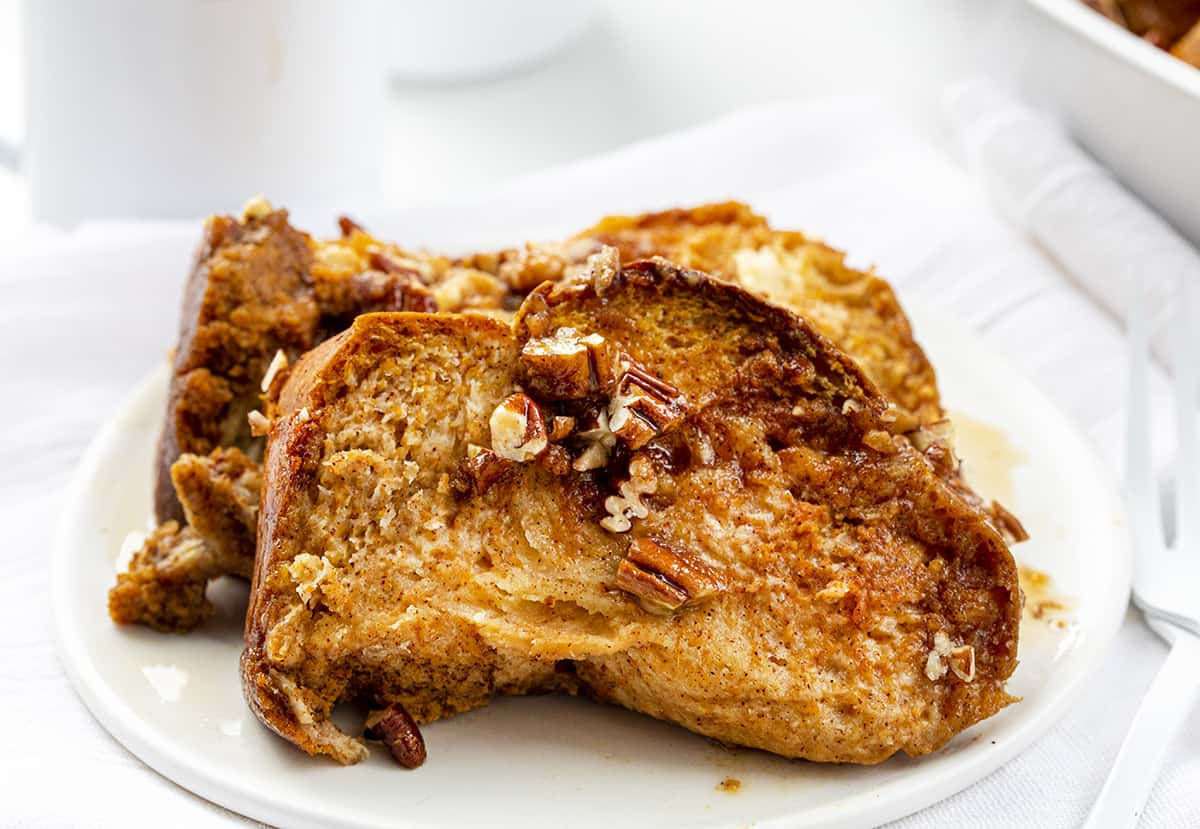 Pieces of Pumpkin French Toast on a White Plate with Coffee in Background.