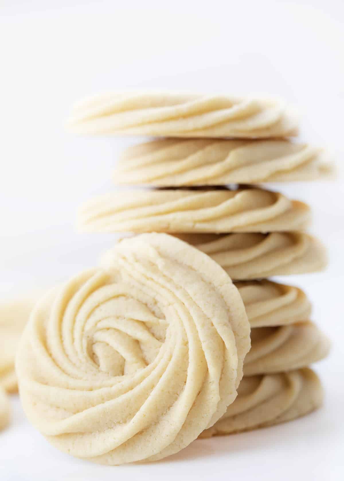A Stack of Butter Cookies with One Facing the Camera and Close So Details Can be Seen.