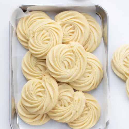 Tray of Butter Cookies on a Counter with Some Cookies off to the Side.