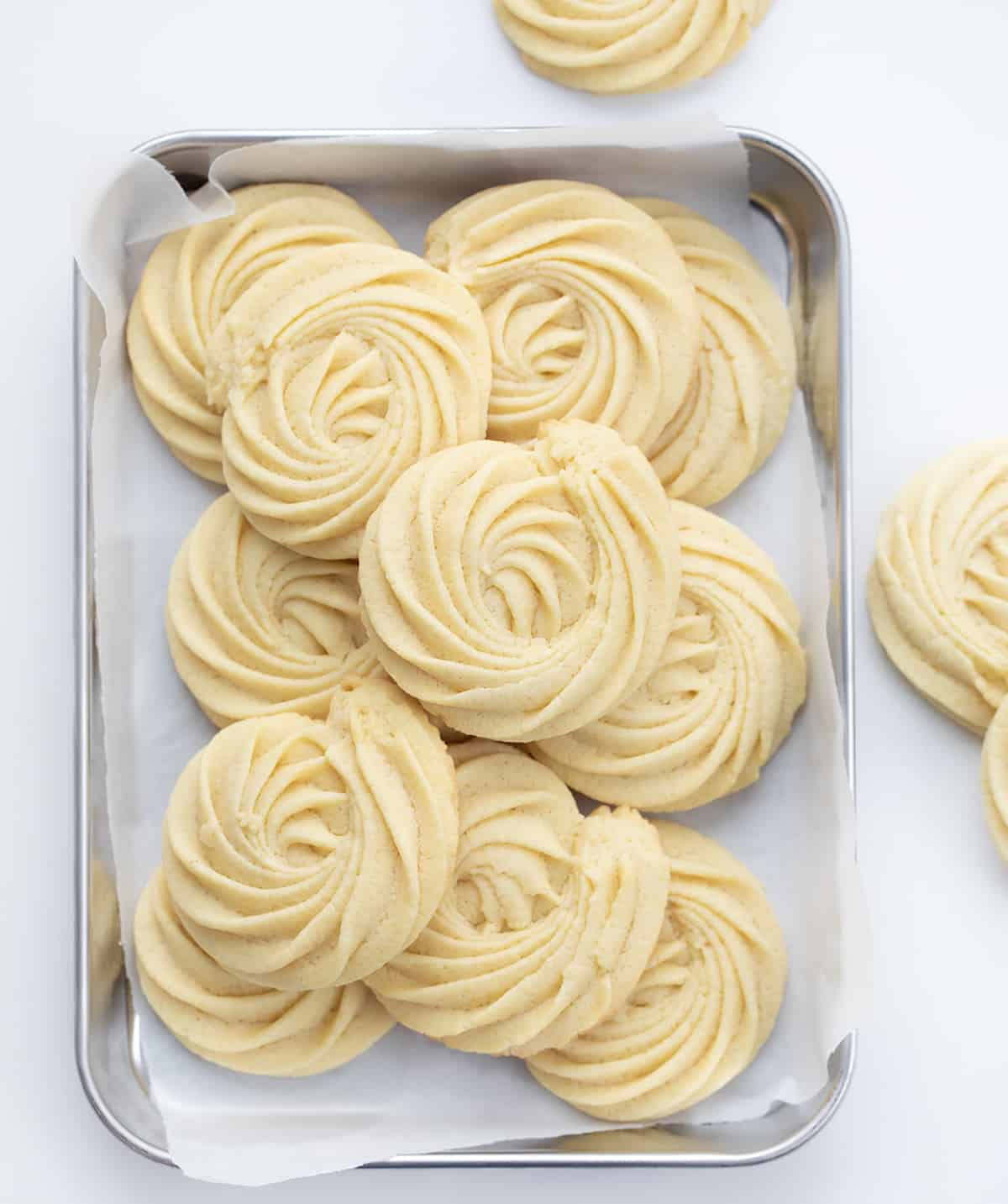 Tray of Butter Cookies on a Counter with Some Cookies off to the Side.