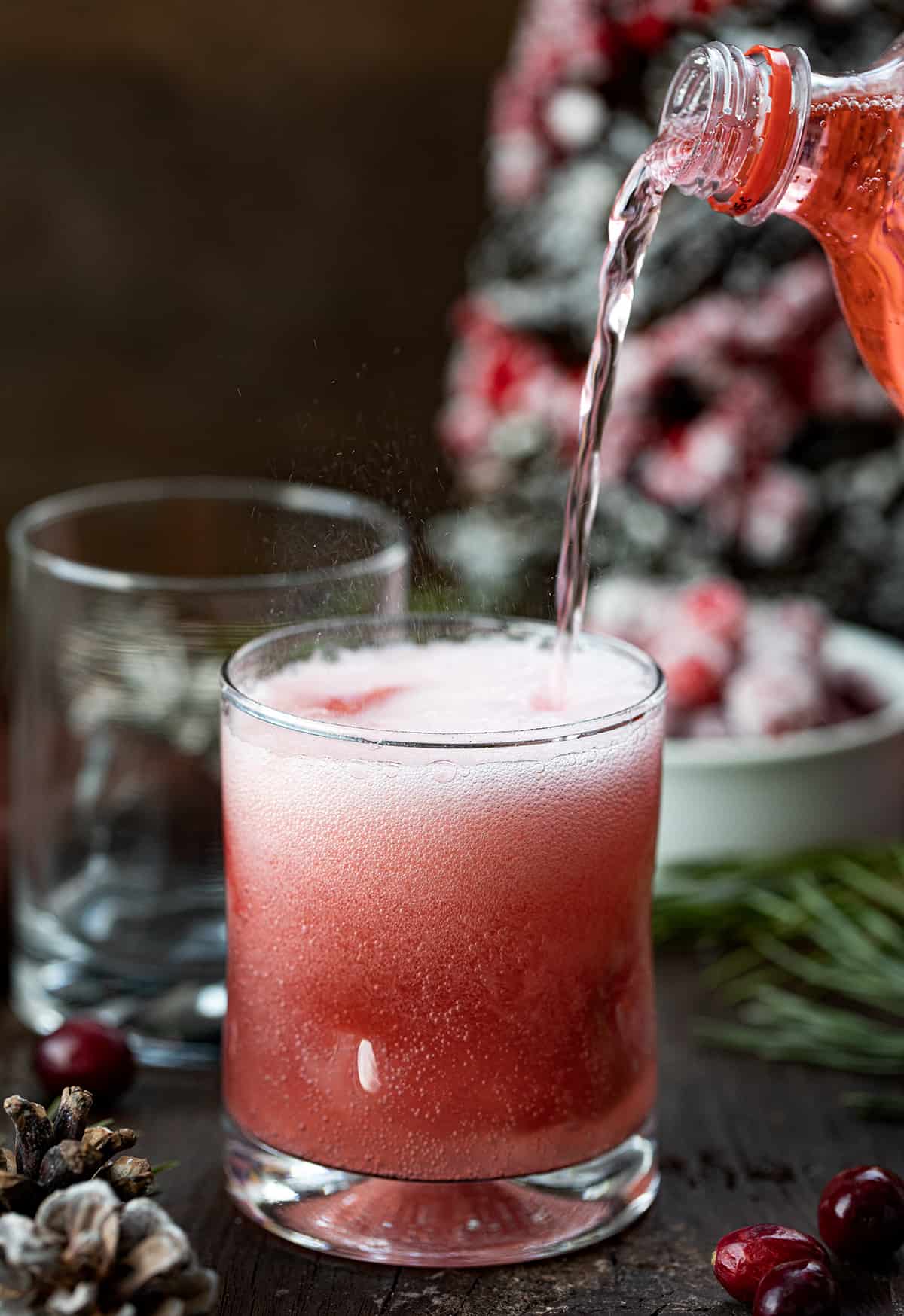 Pouring Cherry Soda into a Christmas Slush Mocktail.