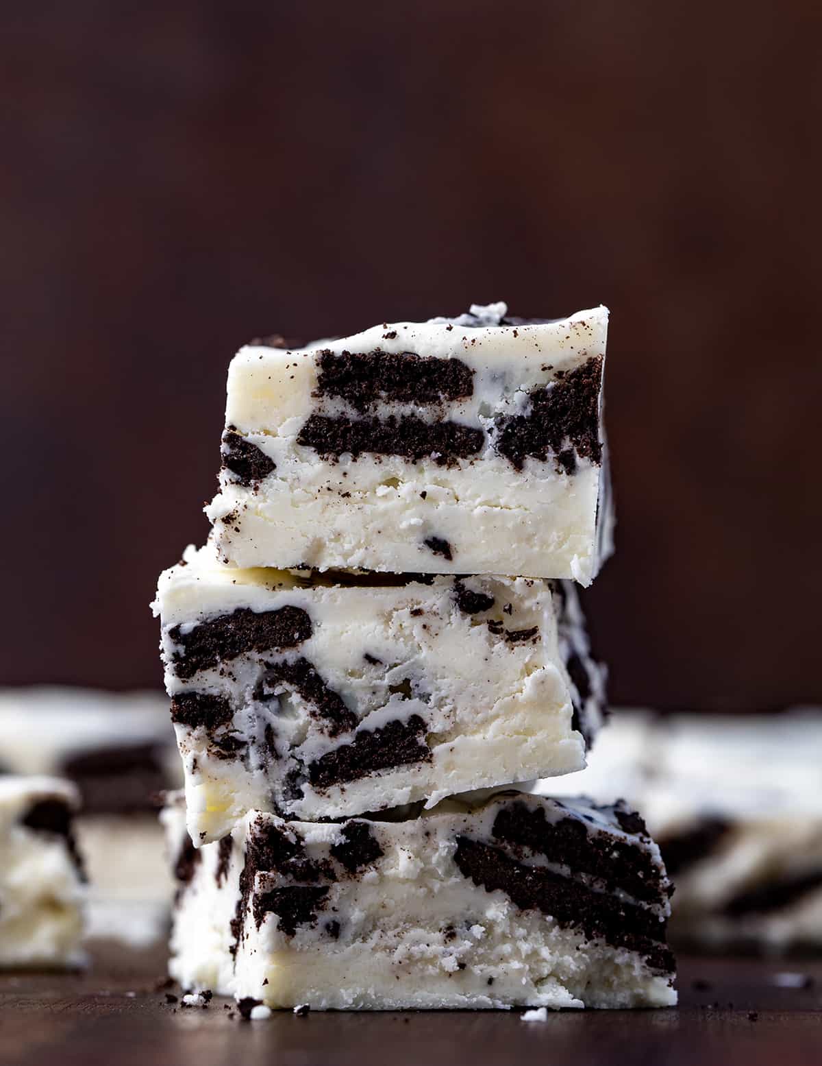 Stack of Cookies and Cream Fudge on a Dark Cutting Board.