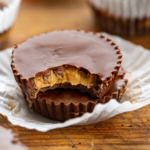 Two Homemade Peanut Butter Cups Stacked and Top One with a Bite Taken Out of It.