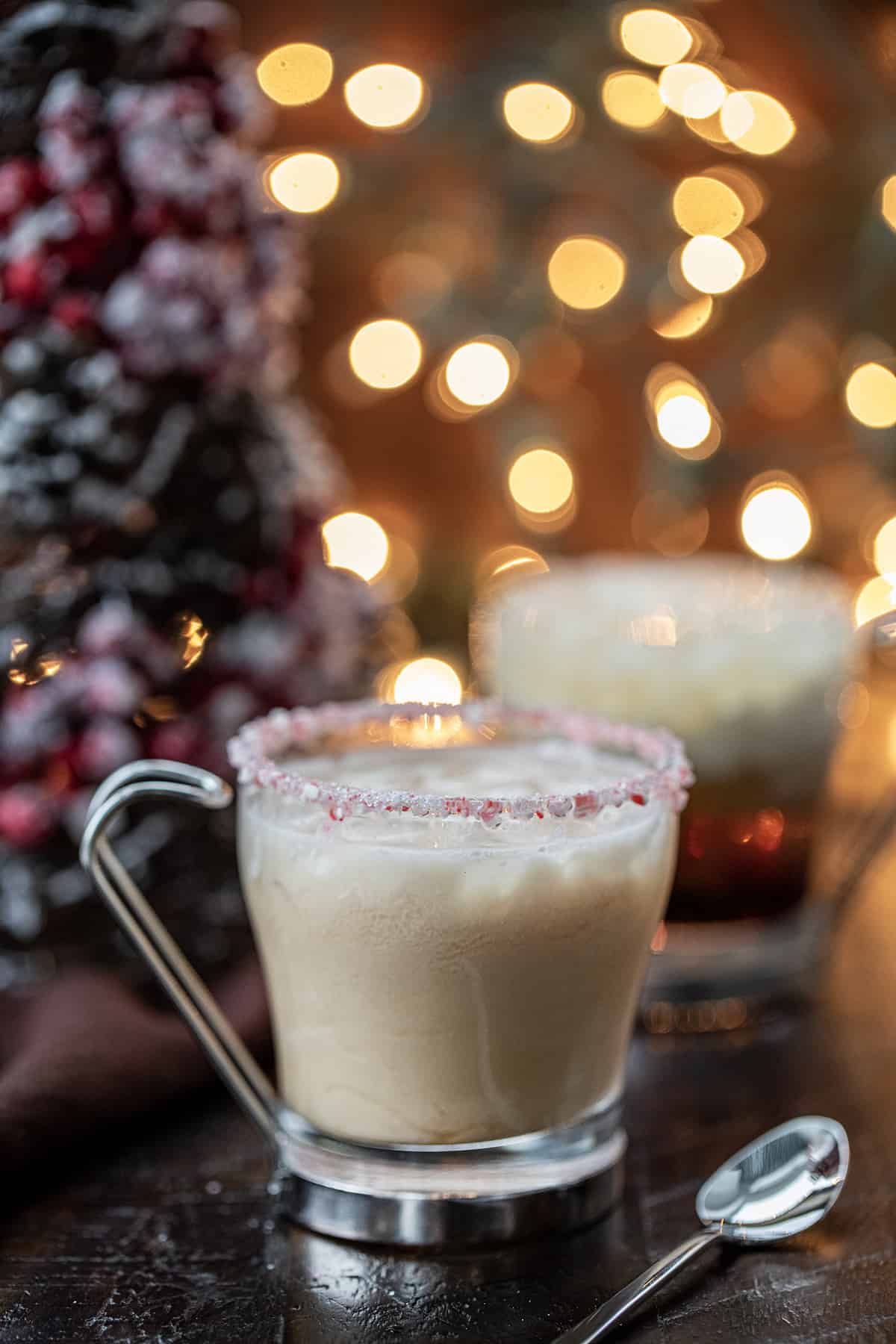 Peppermint White Russians in front of a Christmas Tree and Twinkling Lights.