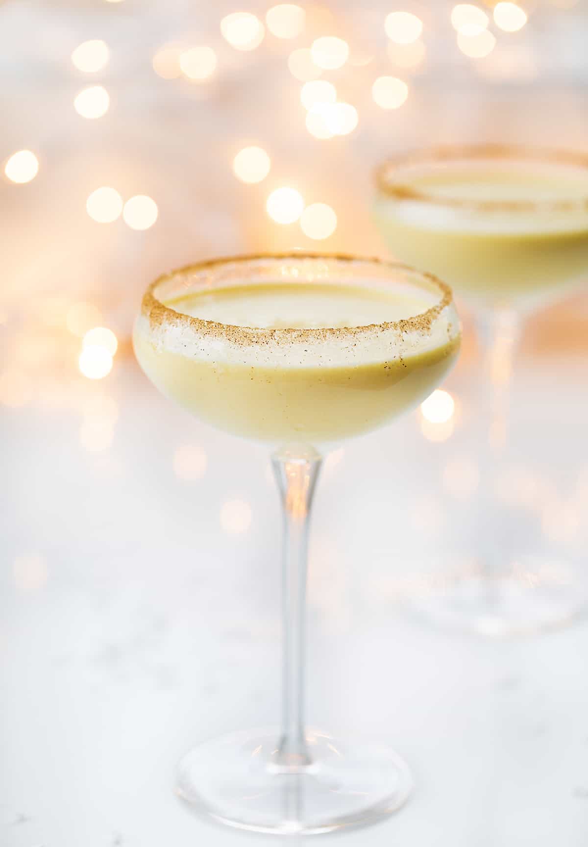 Glasses of RumChata Eggnog in Front of Twinkling Lights.