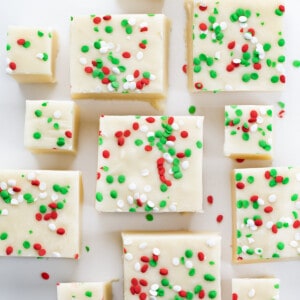 Pieces of Sugar Cookie Fudge on a White COunter with Green and Red Spinkles.