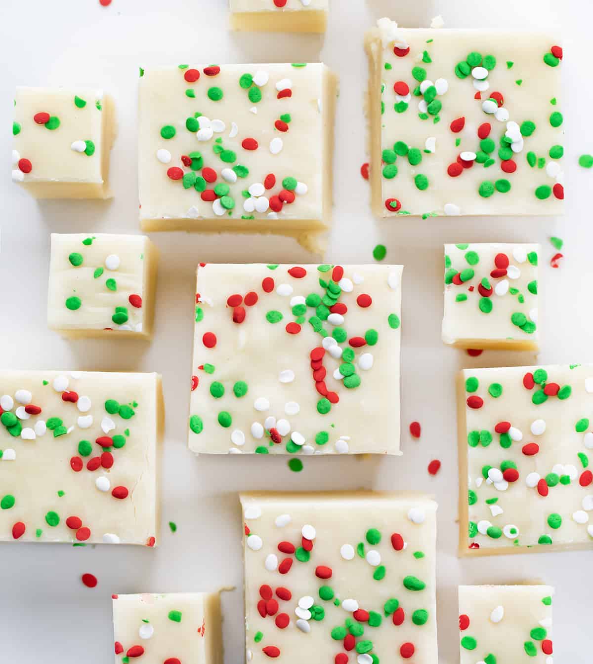 Pieces of Sugar Cookie Fudge on a White COunter with Green and Red Spinkles.