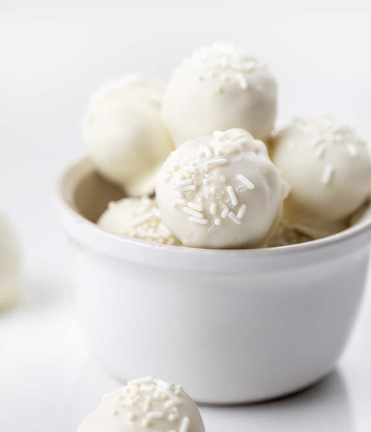 Sugar Cookie Truffles in a White Bowl on a White Counter.