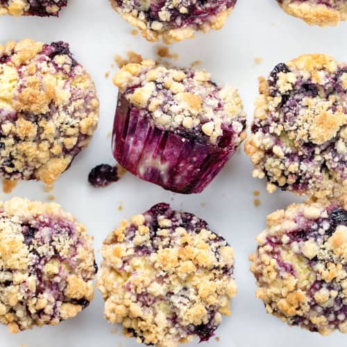 Blueberry Muffins on a Counter with One Tipped on Its Side.