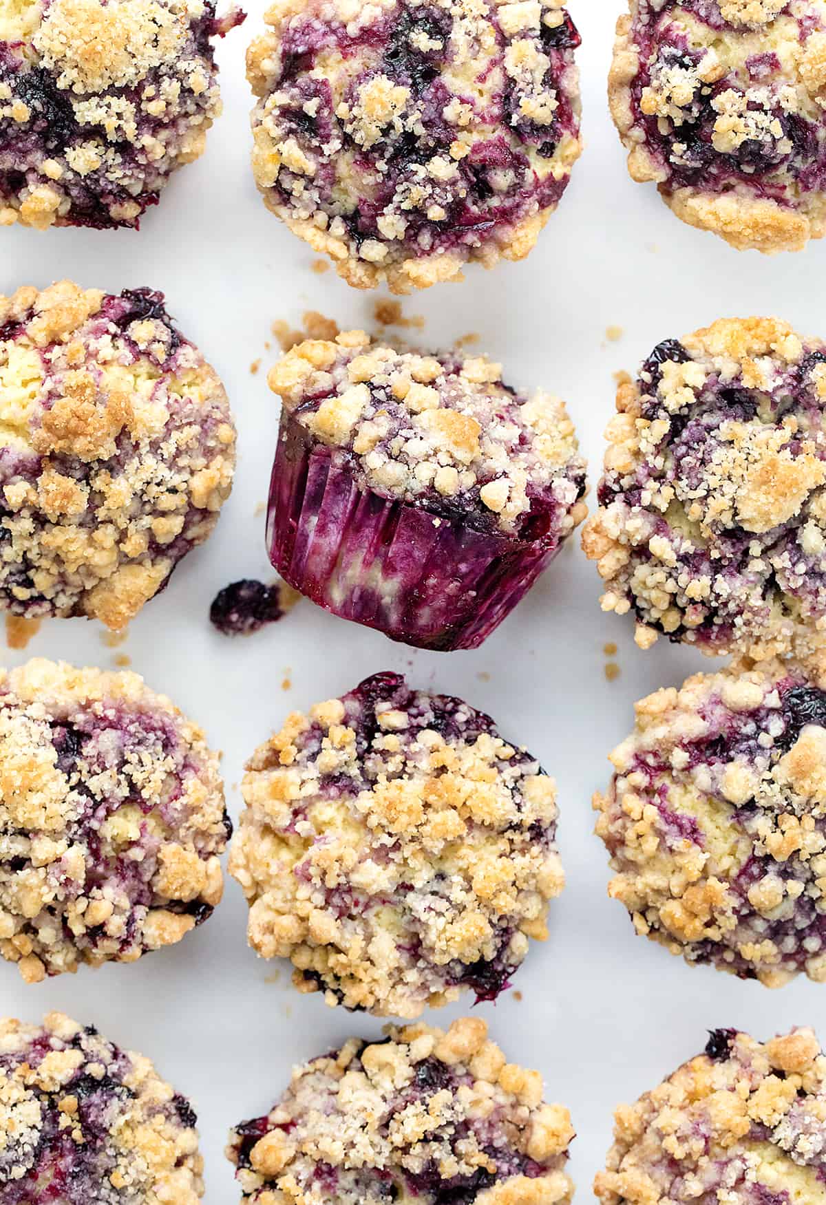 Blueberry Muffins on a Counter with One Tipped on Its Side.