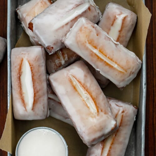 Tray of Glazed Donut Sticks on a Wood Counter.