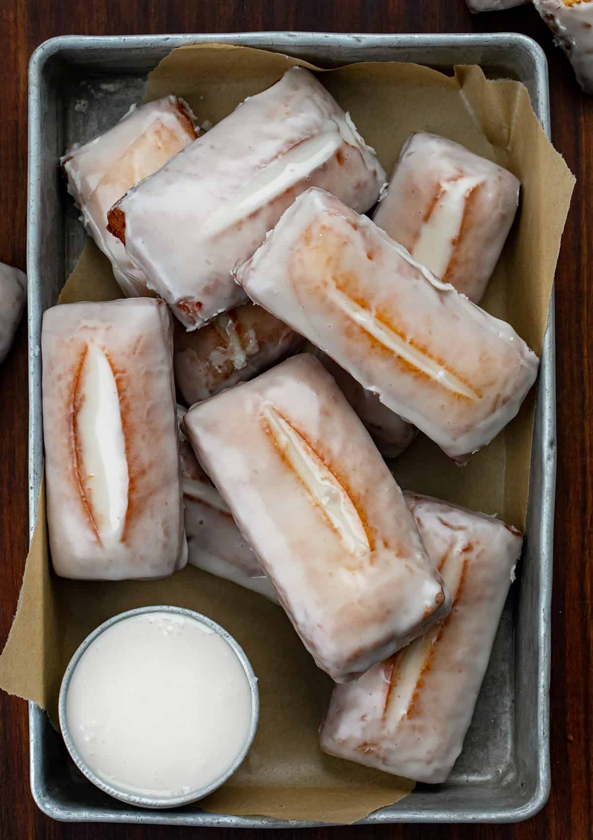 Tray of Glazed Donut Sticks on a Wood Counter.