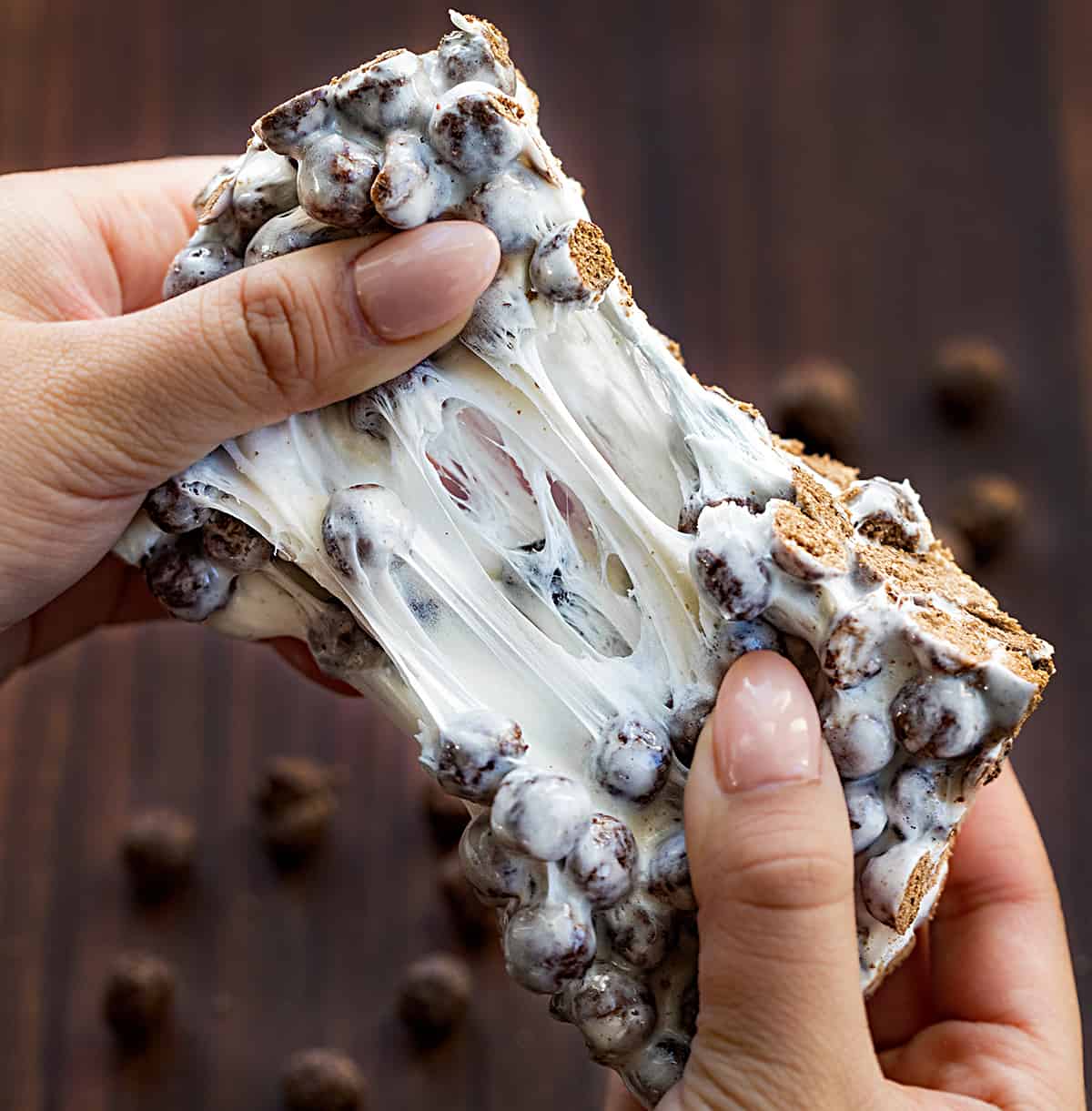 Hand Stretching Apart a Cocoa Puff Bar Showing the Marshmallow Texture.