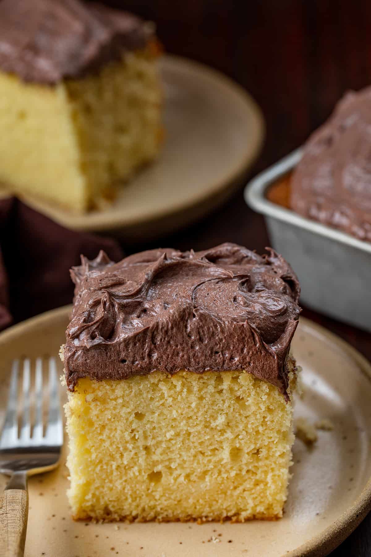 Pieces of Yellow Cake with Chocolate Ermine Frosting on Them.
