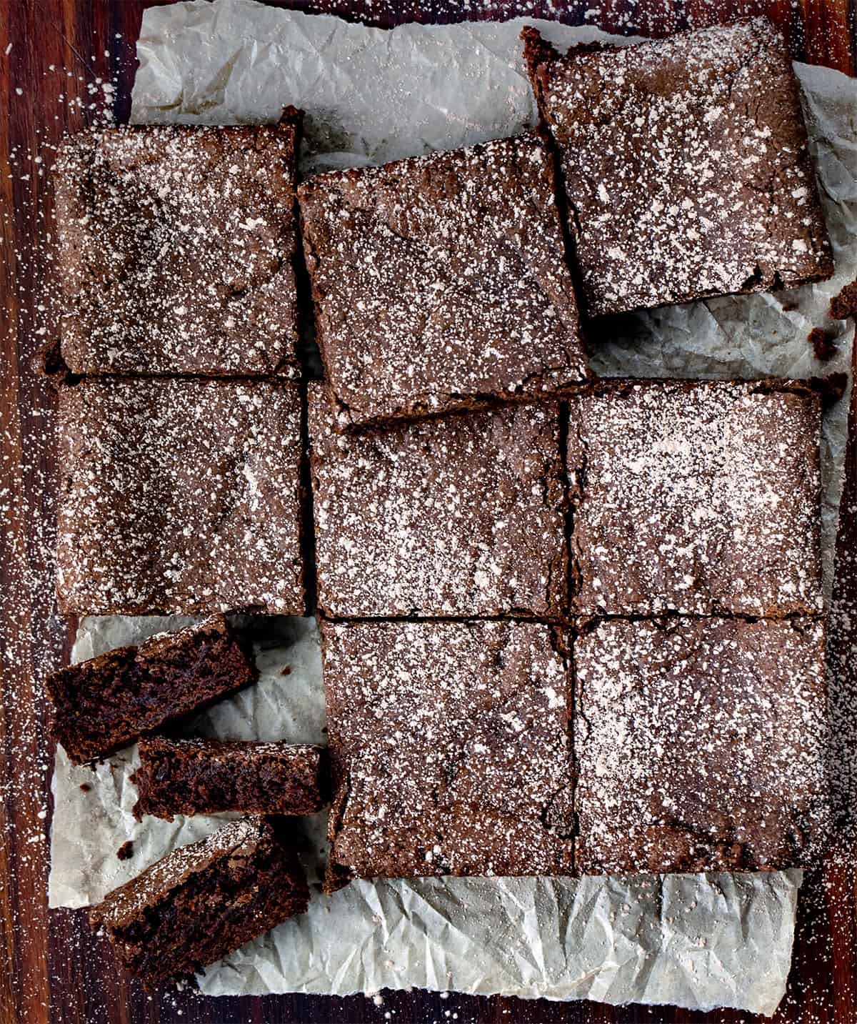 Chocolate Brownies Cut into Squares and One cut Into Pieces Showing Inside.