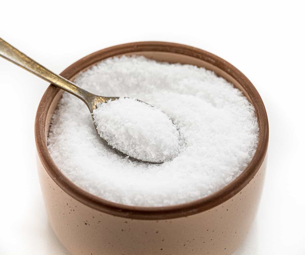 A Container of Kosher Salt with a Spoon in it.