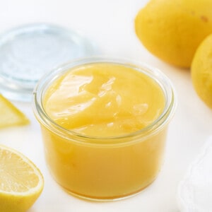 Jar of Lemon Curd next to lemons.