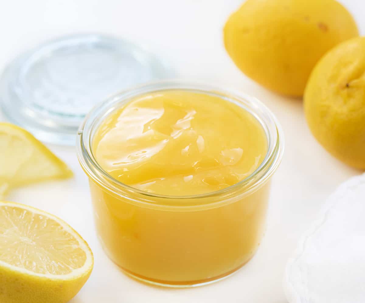 Jar of Lemon Curd next to lemons.