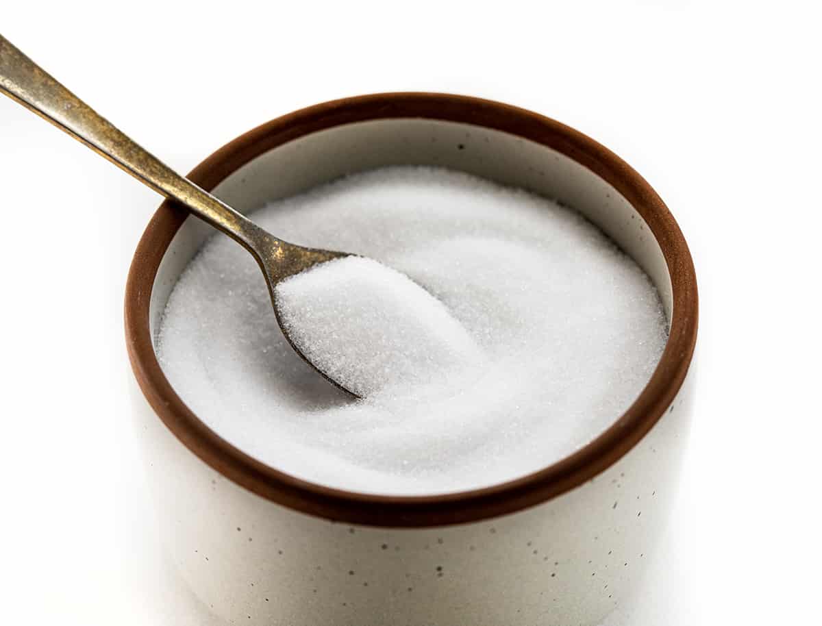 A Container of Table Salt with a Spoon in it.