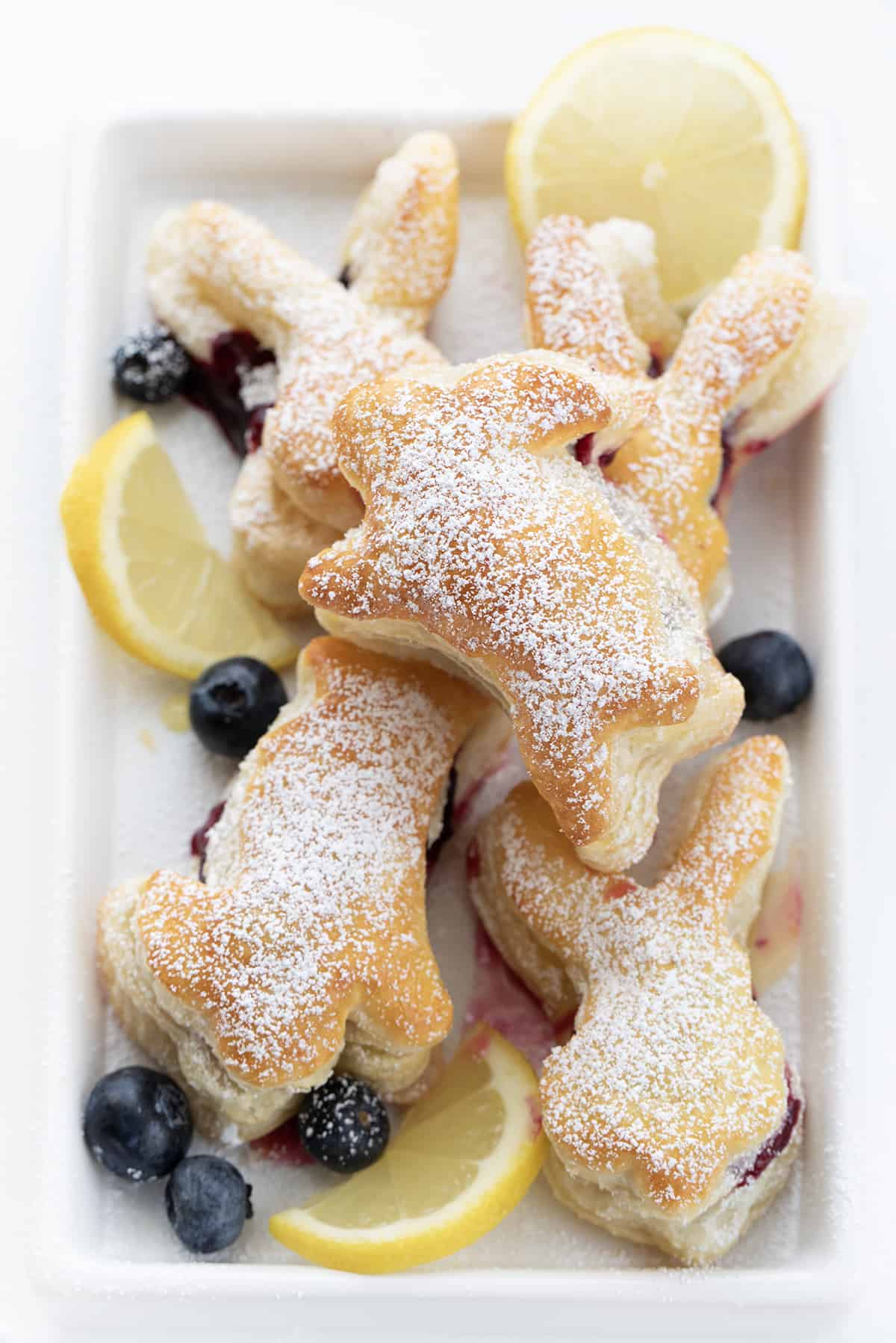 Blueberry Napoleons Shaped in Bunny designs surrounded by blueberries and lemon.