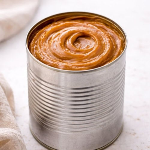 Can of Dulce de Leche on a white table.