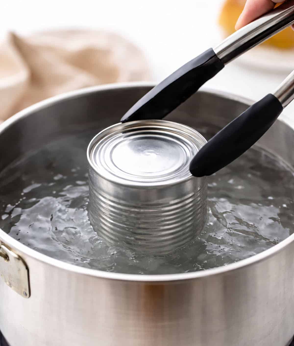 Putting sweetened condensed milk can into boiling water.