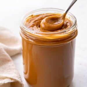 Jar of Dulce de Leche with a full spoon in it.
