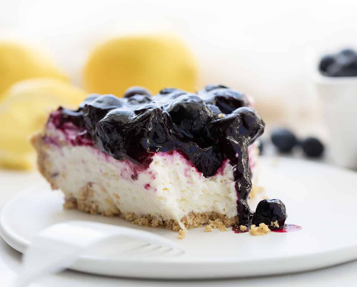 Piece of Blueberry Lemon Cream Pie on a White Plate With a Bite Removed.