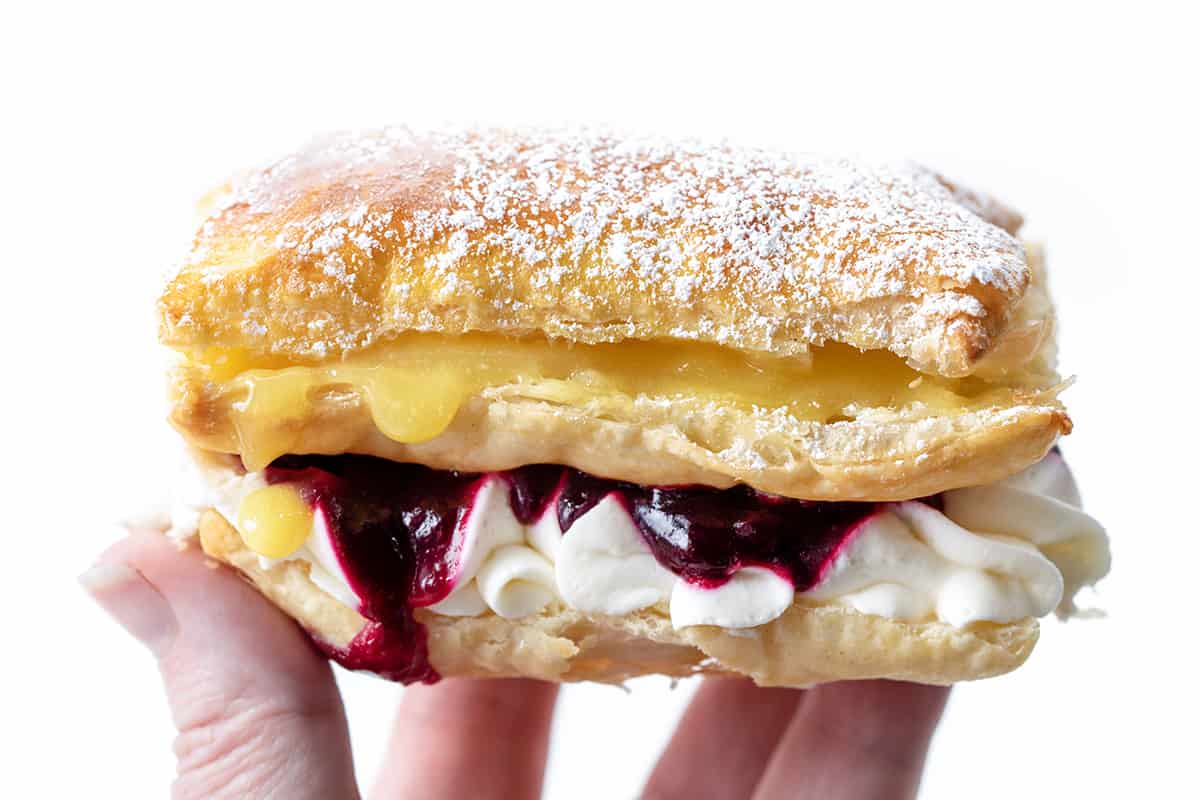 Hand Holding Blueberry Lemon Napoleon so you Can See the Layers.