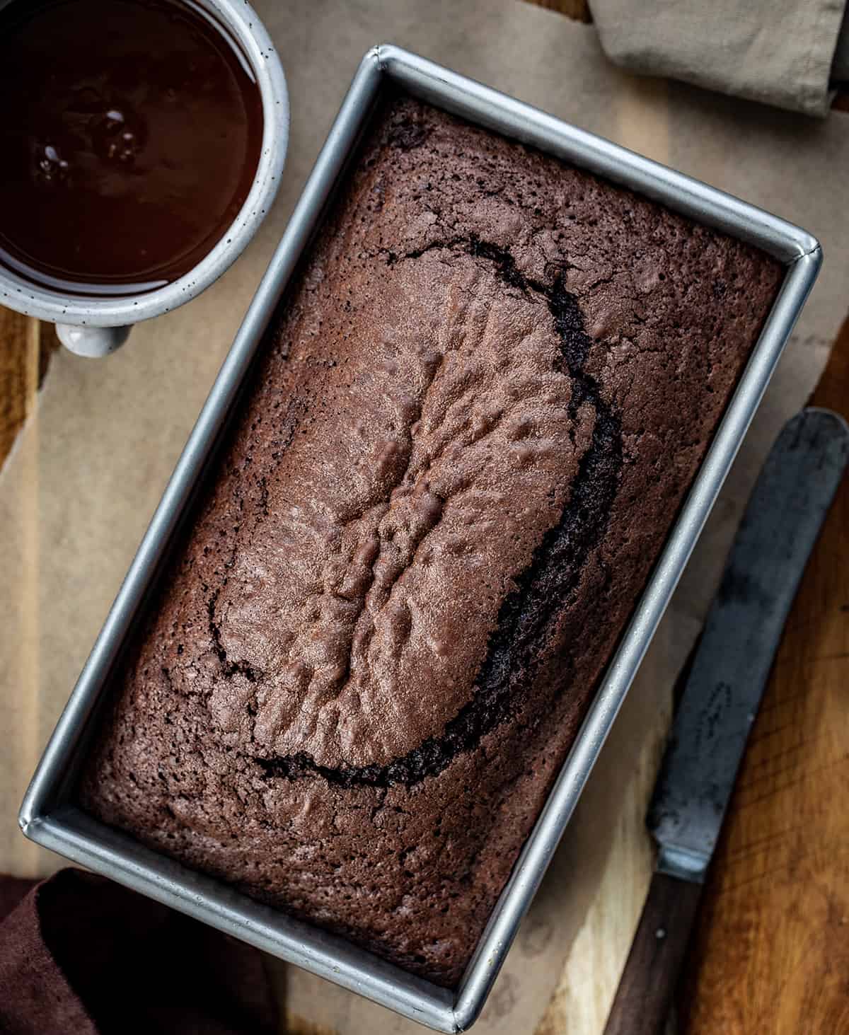 Overhead Image of Brownie Bread with a Knife and Chocolate Glaze for on Top.